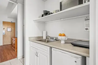 a kitchen with white cabinets and a sink at Stylish 1BR Haven in CanmoreDT near Banff Sleeps 4 in Canmore