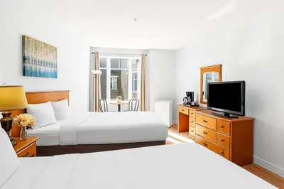 a hotel room with two beds and a flat screen tv at Mini Getaway with Mountain Views Near Banff in Canmore