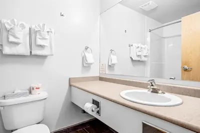a white bathroom with a toilet and a sink at Mini Getaway with Mountain Views Near Banff in Canmore