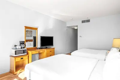 a hotel room with two beds and a television at Mini Getaway with Mountain Views Near Banff in Canmore