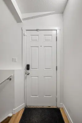 a white door in a room with a black rug at Modern 2BR Private Suite Near Calgary Airport in Calgary