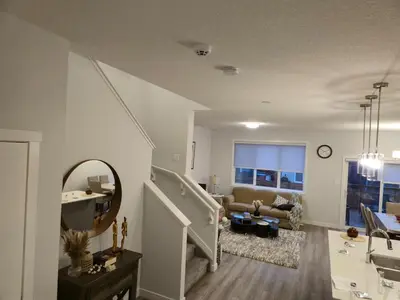 a living room with a staircase and a couch at Sunny's Homes in Edmonton