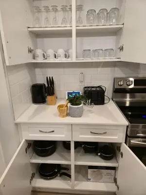 a kitchen with white cabinets and a counter top at Sunny's Homes in Edmonton