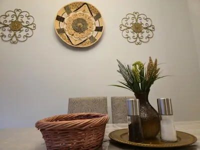 a table with a vase and plates on a wall at Sunny's Homes in Edmonton