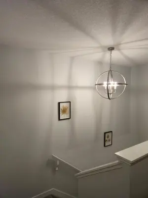 a white room with a chandelier hanging from the ceiling at Sunny's Homes in Edmonton