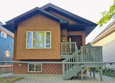 a small house with a fence in front of it at Central 3 Bedroom Gem Near ICE District - Stadium and Malls in Edmonton