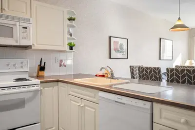 a kitchen with white appliances and a sink at The Pinnacle in Fairmont 1BR Condo Near Hot Springs in Fairmont Hot Springs