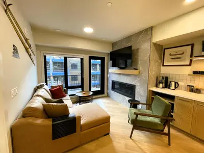 a living room with a couch and a chair at Black Bears Den, Heated Pool, Hot Tub, Brand NEW! in Canmore