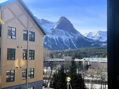 a building with a view of a mountain at Black Bears Den, Heated Pool, Hot Tub, Brand NEW! in Canmore