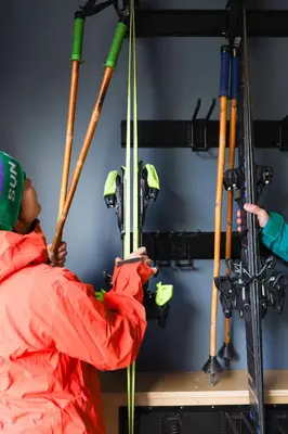 a man holding skis on a ski lift at The Après Arcade in Sun Peaks