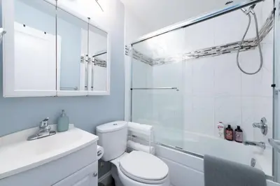 a bathroom with a toilet and a glass shower at 2 bedroom suite Walk to SkyTrain, Grocery, Macdonald & more in Vancouver