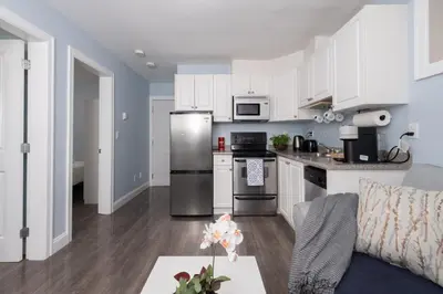 a kitchen with white cabinets and stainless steel appliances at 2 bedroom suite Walk to SkyTrain, Grocery, Macdonald & more in Vancouver