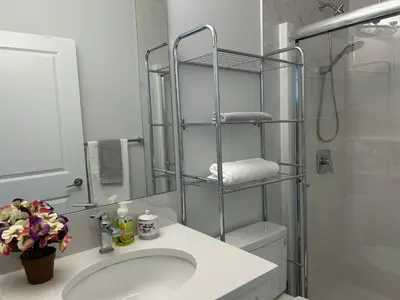 a bathroom with a sink and a toilet and a shower at Sunny Queen-size Bedroom with Private Bath in Brand New House in Calgary