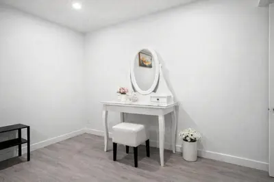 a white dressing table with a mirror and a stool at New 2BR Suite, Walk to Dining, Near Downtown in Calgary