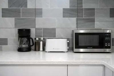 a kitchen counter with a microwave and a coffee maker at New 2BR Suite, Walk to Dining, Near Downtown in Calgary