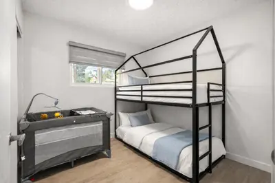 a bedroom with a black bunk bed and a desk at Bright 5-Bed Retreat Near the Zoo and Downtown in Calgary