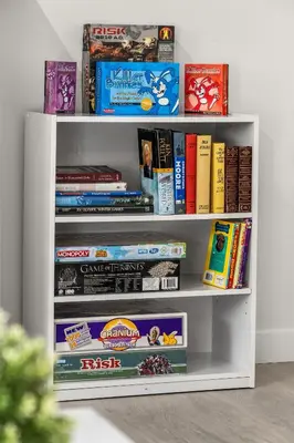 a white book shelf filled with lots of books at Bright 5-Bed Retreat Near the Zoo and Downtown in Calgary