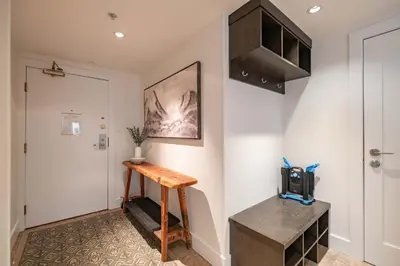 a hallway with a wooden table and a door at Woodrun Lodge 108 by Outpost Whistler in Whistler