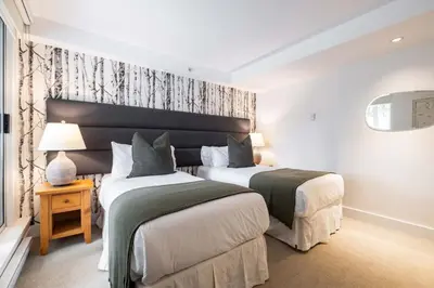a bedroom with two beds and a window at Woodrun Lodge 108 by Outpost Whistler in Whistler