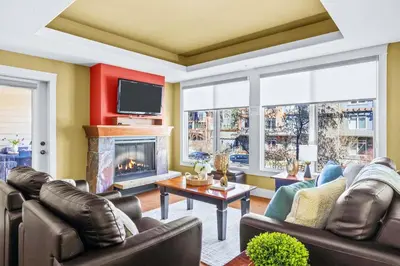 a living room with leather furniture and a fireplace at Exciting Rockies 1BR Escape with Hot Tub, Pool and BBQ in Canmore