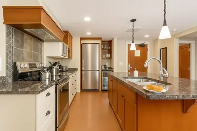a large kitchen with a sink and a refrigerator at Mountain Bliss Spacious 2BR with Pool and Hot Tub in Canmore