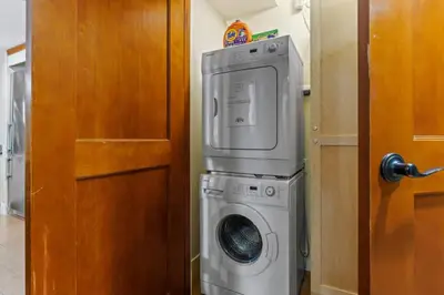 a washer and dryer in a room next to a door at Mountain View Escape Sleeps 6 with Hot Tub and Pool in Canmore