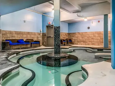 a pool in a hotel lobby with a fountain at Mountain View Escape Sleeps 6 with Hot Tub and Pool in Canmore
