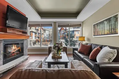 a living room with a couch and a fireplace at Mountain View Escape Sleeps 6 with Hot Tub and Pool in Canmore