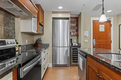 a large kitchen with a stainless steel refrigerator at Mountain View Escape Sleeps 6 with Hot Tub and Pool in Canmore