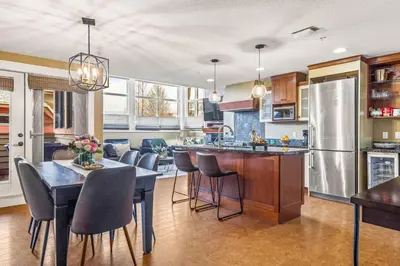 a kitchen and dining room with a table and chairs at Cozy 2BR Retreat Mountain View with Pool and Hot Tub in Canmore