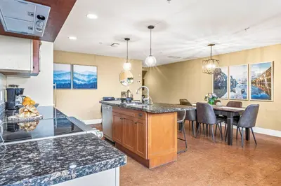 a kitchen with a table and a dining room at Cozy 2BR Retreat Mountain View with Pool and Hot Tub in Canmore