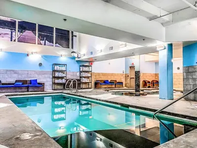 a swimming pool in a large room with a swimming pool at Cozy 2BR Retreat Mountain View with Pool and Hot Tub in Canmore