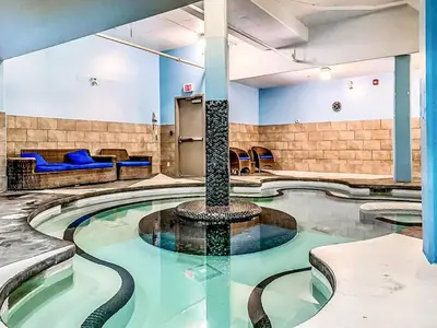 a pool with a fountain in the middle of a room at Cozy 2BR Retreat Mountain View with Pool and Hot Tub in Canmore