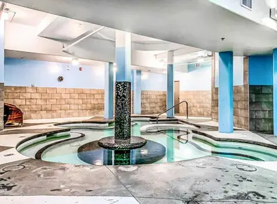 a swimming pool with a fountain in a building at Cozy 2BR Retreat Mountain View with Pool and Hot Tub in Canmore