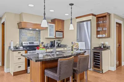a kitchen with a large island with bar chairs at Spacious Rockies Escape near Banff Hot tub and Gym in Canmore