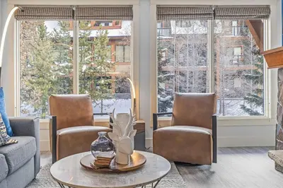 a living room with two chairs and a table at Spacious 2BR Oasis with Pool and Gym Close to Banff in Canmore