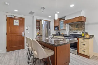 a kitchen with a island with bar stools at Spacious 2BR Oasis with Pool and Gym Close to Banff in Canmore