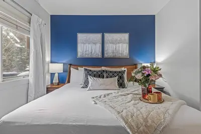 a bedroom with blue walls and a large bed at Spacious 2BR Oasis with Pool and Gym Close to Banff in Canmore
