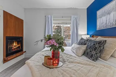 a bedroom with a bed with a fireplace at Spacious 2BR Oasis with Pool and Gym Close to Banff in Canmore
