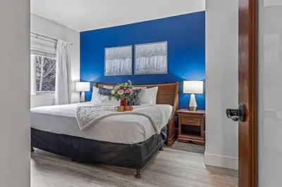 a bedroom with blue walls and a bed with flowers on it at Spacious 2BR Oasis with Pool and Gym Close to Banff in Canmore