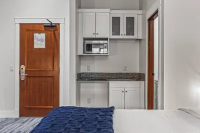 a bedroom with a bed and a wooden door at Mountain View Penthouse with Pool and Hot Tub in Canmore