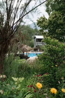 a garden with a swimming pool and a house at Similkameen Valley Resort in Cawston
