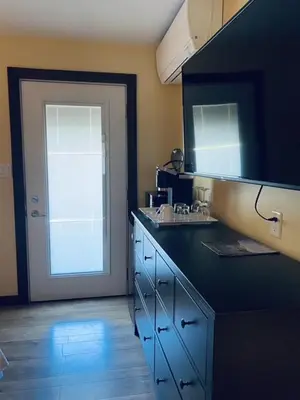 a kitchen with a blue counter and a door with a sink at Similkameen Valley Resort in Cawston