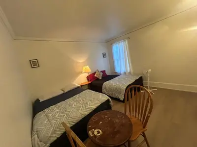 a bedroom with two beds and a table and chairs at Vancouver Guest House - Airport 10 Min, Downtown 15 Min - Free Parking & Fast Wi-Fi in Vancouver