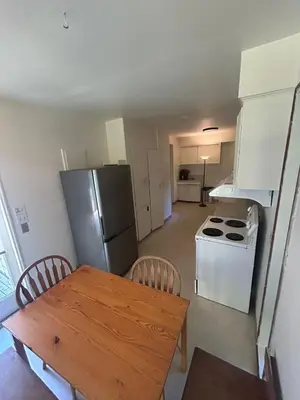 a kitchen with a wooden table and a refrigerator at Vancouver Guest House - Airport 10 Min, Downtown 15 Min - Free Parking & Fast Wi-Fi in Vancouver