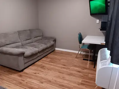 a living room with a couch and a desk with a television at Hinton Highway Inn in Hinton