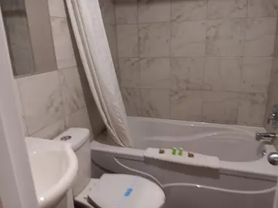a bathroom with a toilet and a tub and a sink at Hinton Highway Inn in Hinton