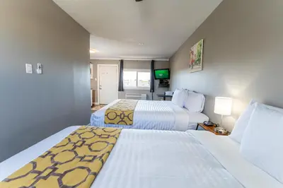 a hotel room with two beds and a television at Hinton Highway Inn in Hinton