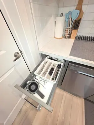 a small kitchen with a stove top oven next to a refrigerator at Amaville - Two BRM Suite in West Edmonton in Edmonton