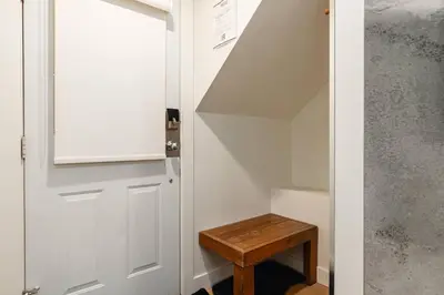 a stairway with a white door and a wooden stool at Private Hot Tub | Pool | Free Parking | Sauna in Whistler